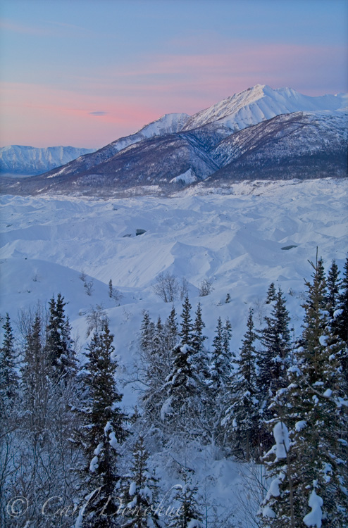 Dawn rises over Fireweed Mountain, wintertime, in the Wrangell Mountains. Looking across the Kennicott Glacier moraine, Wrangell St. Elias National Park and Preserve, Alaska.